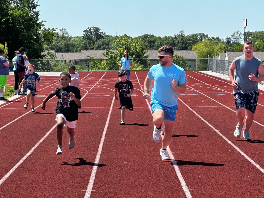 Students racing on the track during High Road School Field Day activities