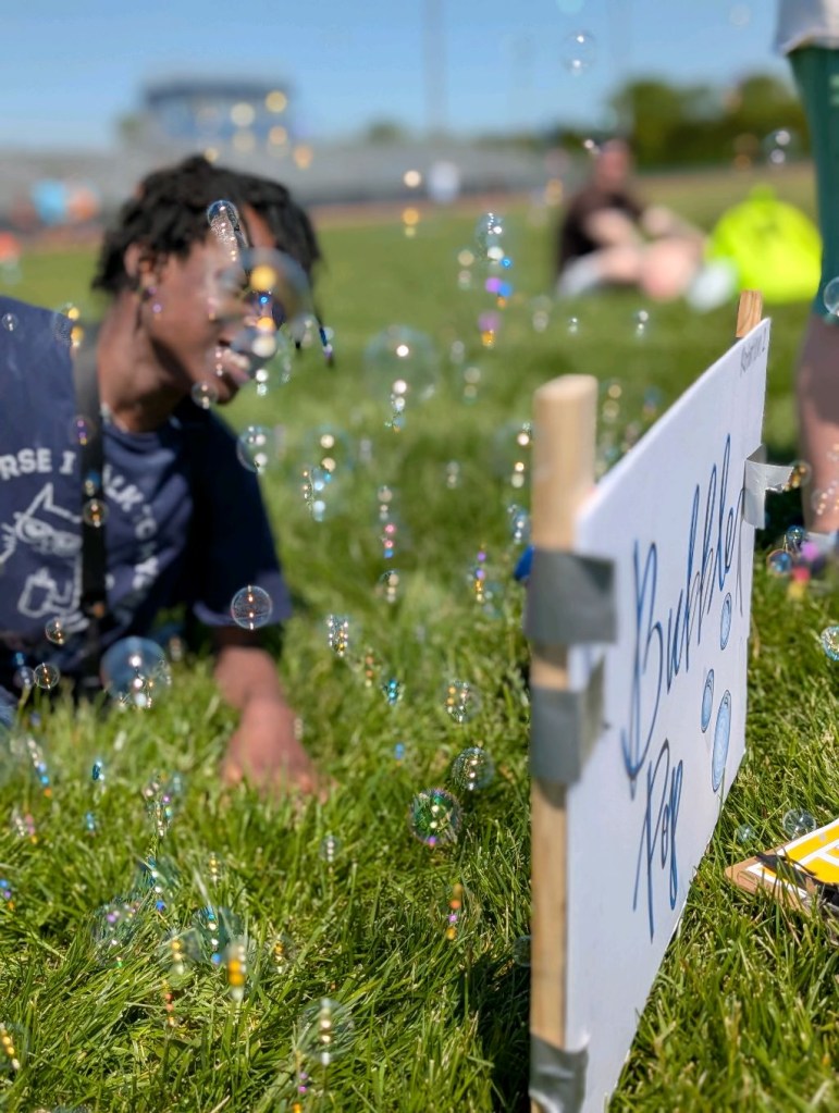 Student enjoying bubbles and outdoor games during Field Day celebrations
