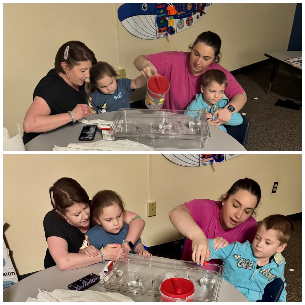 Staff assisting students with pouring water and colored liquid into cups during a classroom science activity.