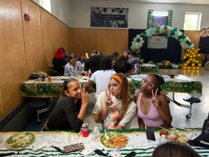 Phoenix Academy seniors gathered together during the Class of 2026 graduation luncheon celebration with decorated tables and graduation displays in the background