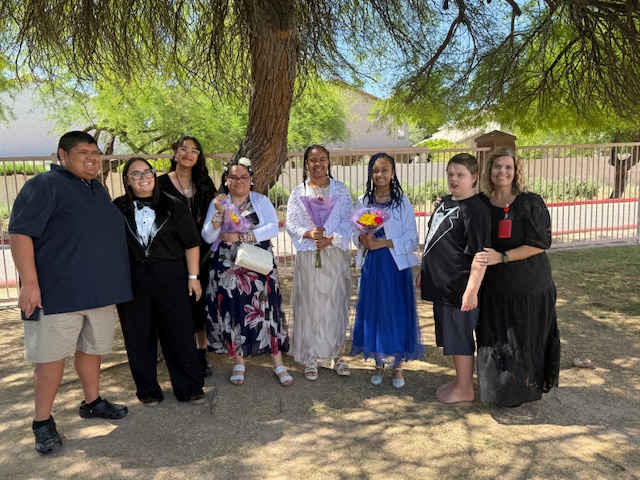 Students and staff from Sierra School of Gilbert posing outdoors in formal prom attire