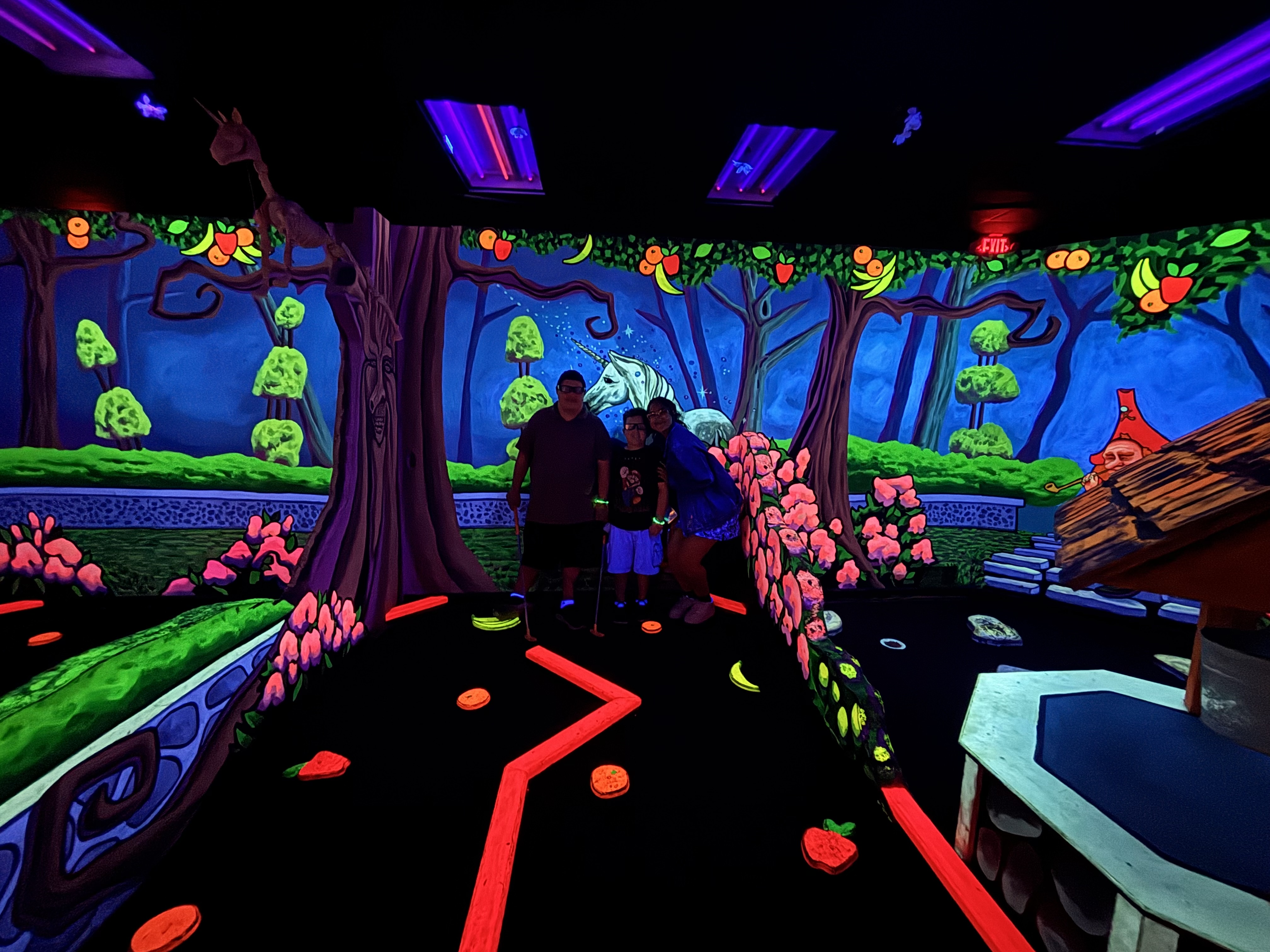 Sierra students posing together inside a colorful glow-in-the-dark mini golf course at 3D Mini Golf in Gilbert.