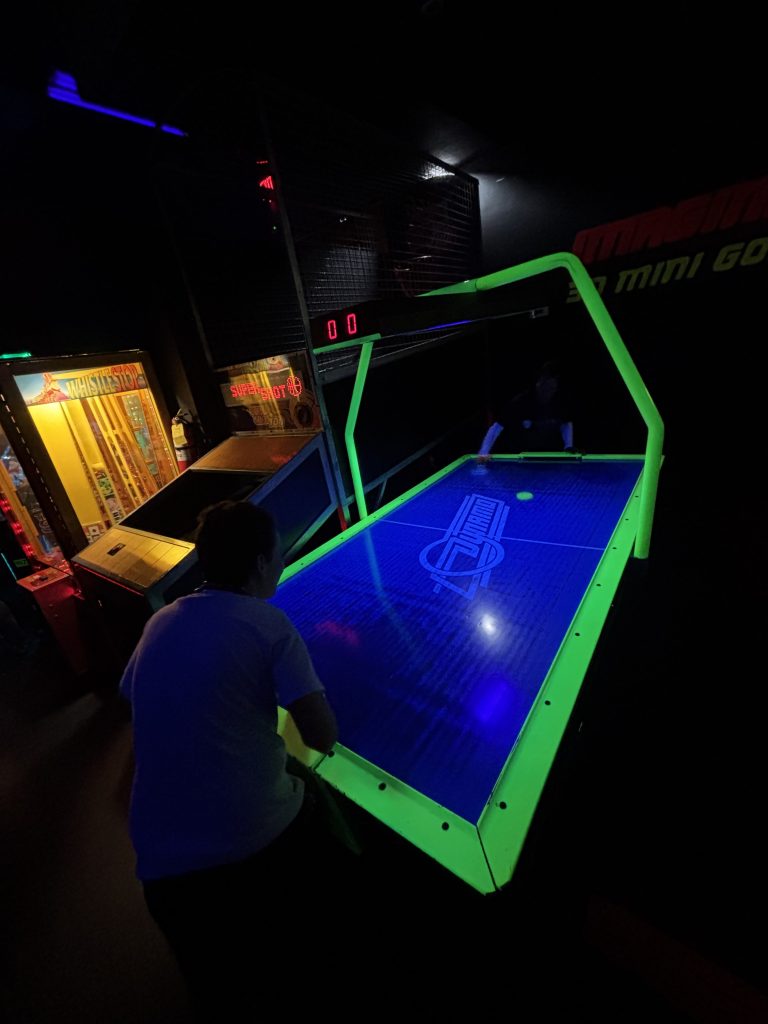 Students playing glow hockey arcade game during Fun Friday reward outing at 3D Mini Golf in Gilbert.