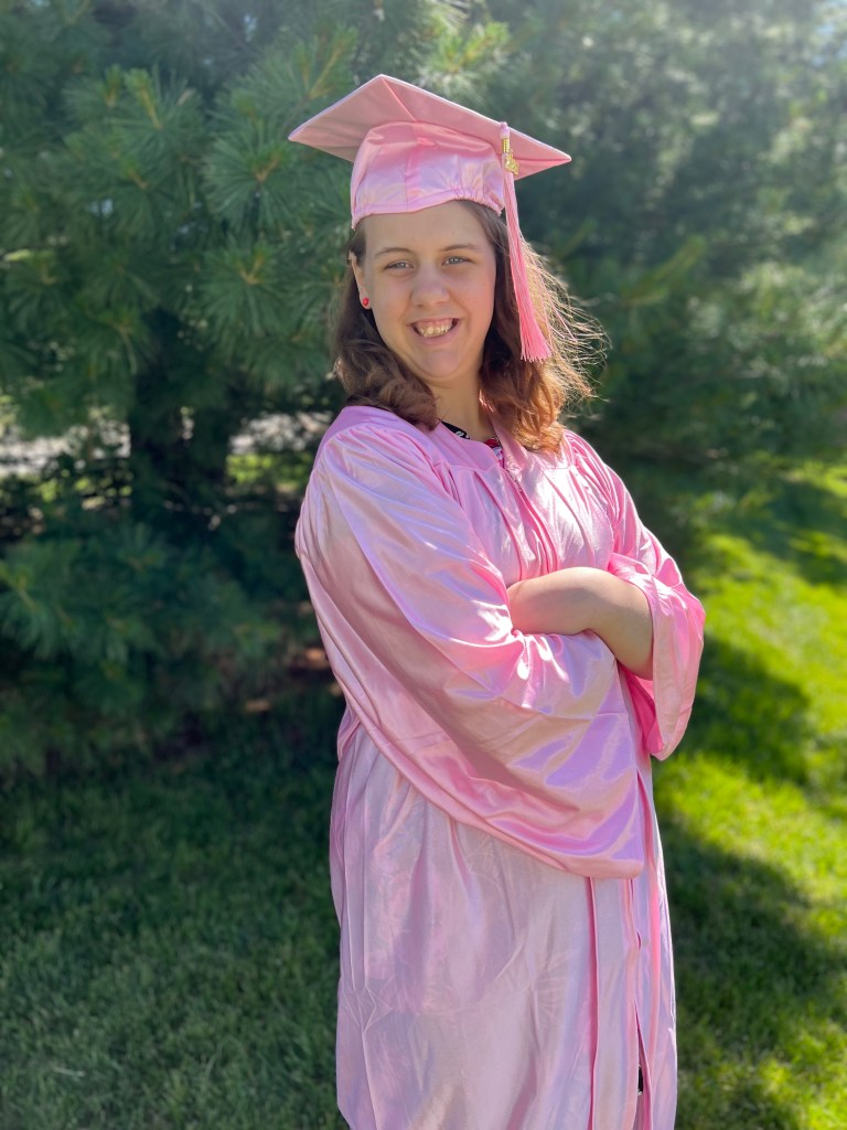 High Road School graduate wearing a pink cap and gown during the 2026 graduation celebration
