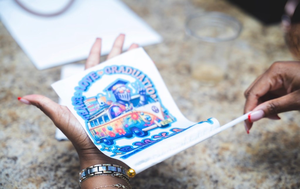 Student holding a custom graduation themed keepsake during the eighth grade luncheon.