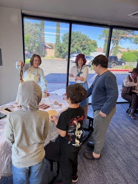 Students visiting a table of historical artifacts during a California history exhibition