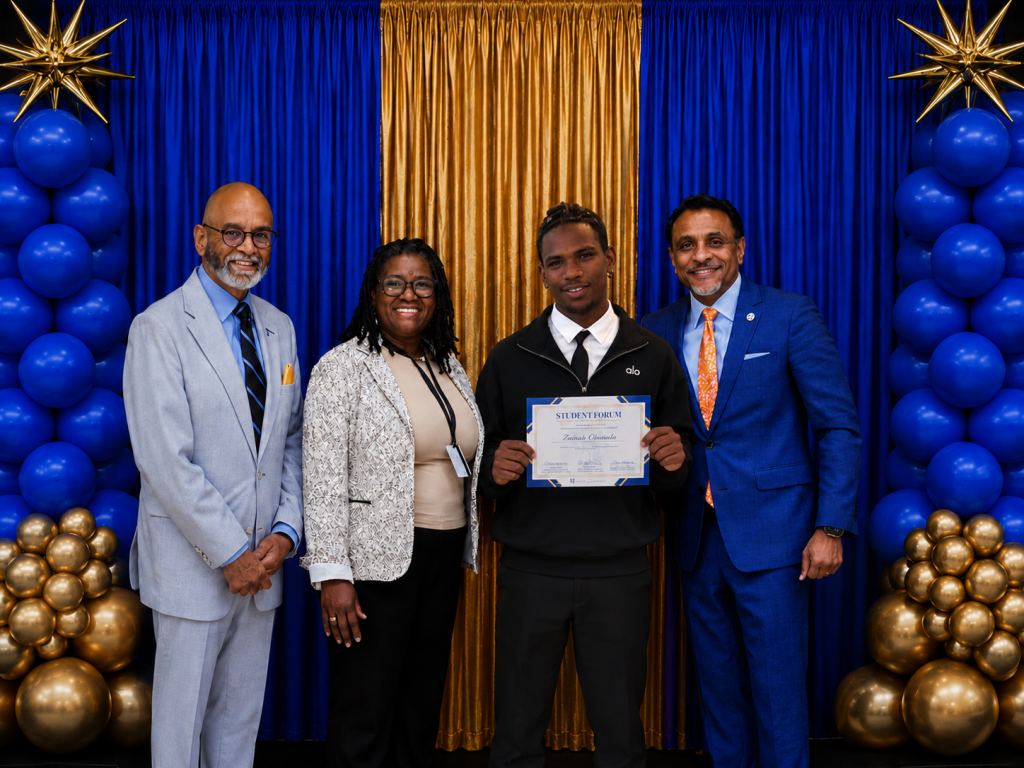 El estudiante galardonado posa junto a los responsables del ámbito educativo tras recibir un reconocimiento académico en la celebración celebrada en Filadelfia.