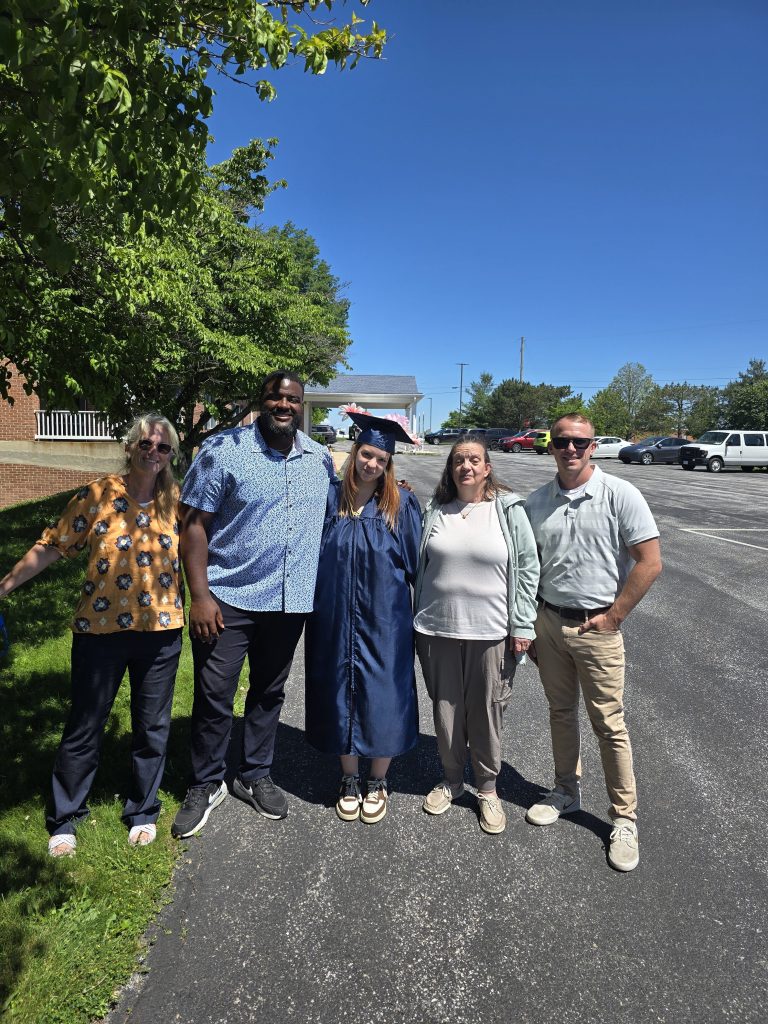 Cheyanne posa con miembros del personal tras su ceremonia de graduación.