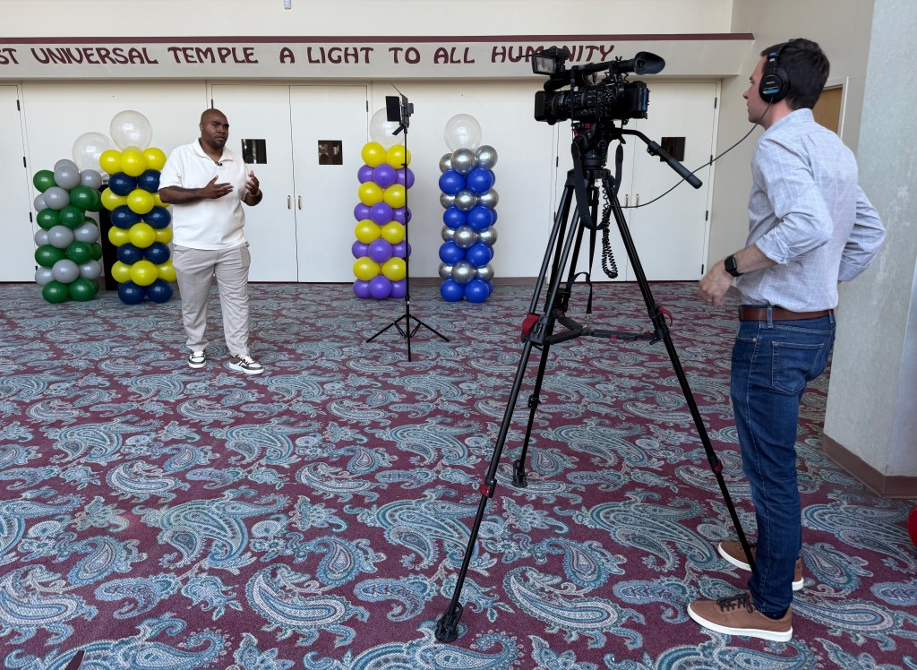 Excel Academy of Englewood alumnus Raynard Gillespie being interviewed during a graduation celebration at Excel Academies in Chicago.
