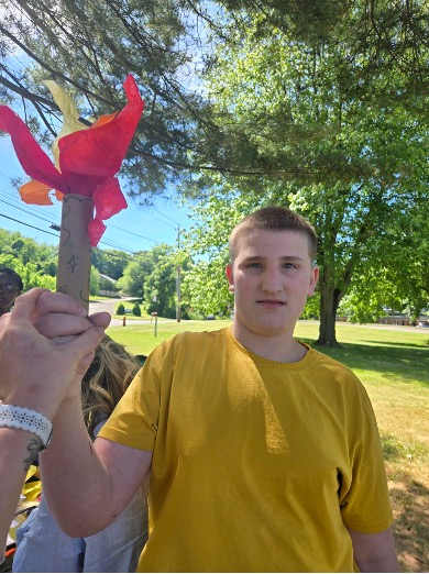 Student proudly displaying a handmade team torch craft.