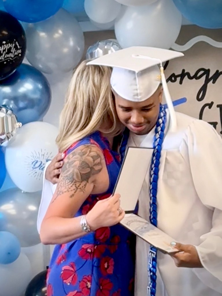 A graduate receives a diploma and a congratulatory hug during Sierra School of Gateway's Class of 2026 celebration.