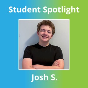 Josh S., alumno de la High Road School del condado de Anne Arundel, sonríe con los brazos cruzados mientras posa de pie junto a una pared de color claro durante una sesión fotográfica dedicada a los alumnos.