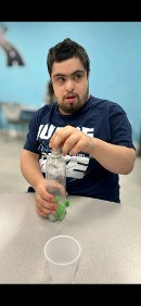 Matthew participating in a hands-on classroom activity at a table.