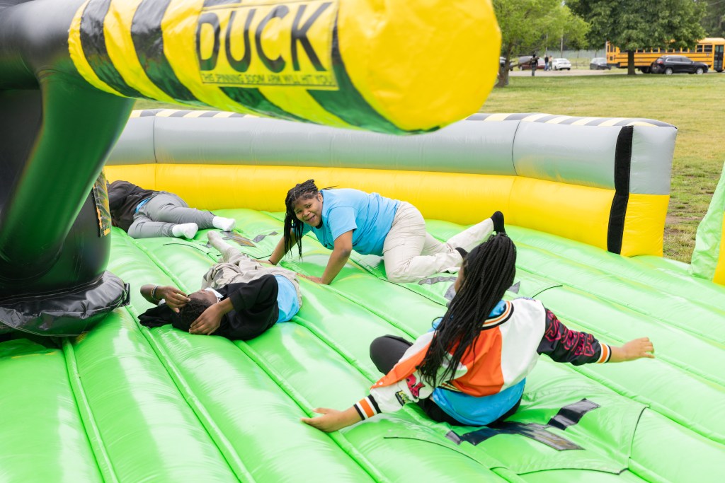 Students laugh and play on an inflatable attraction during the annual May Day celebration.