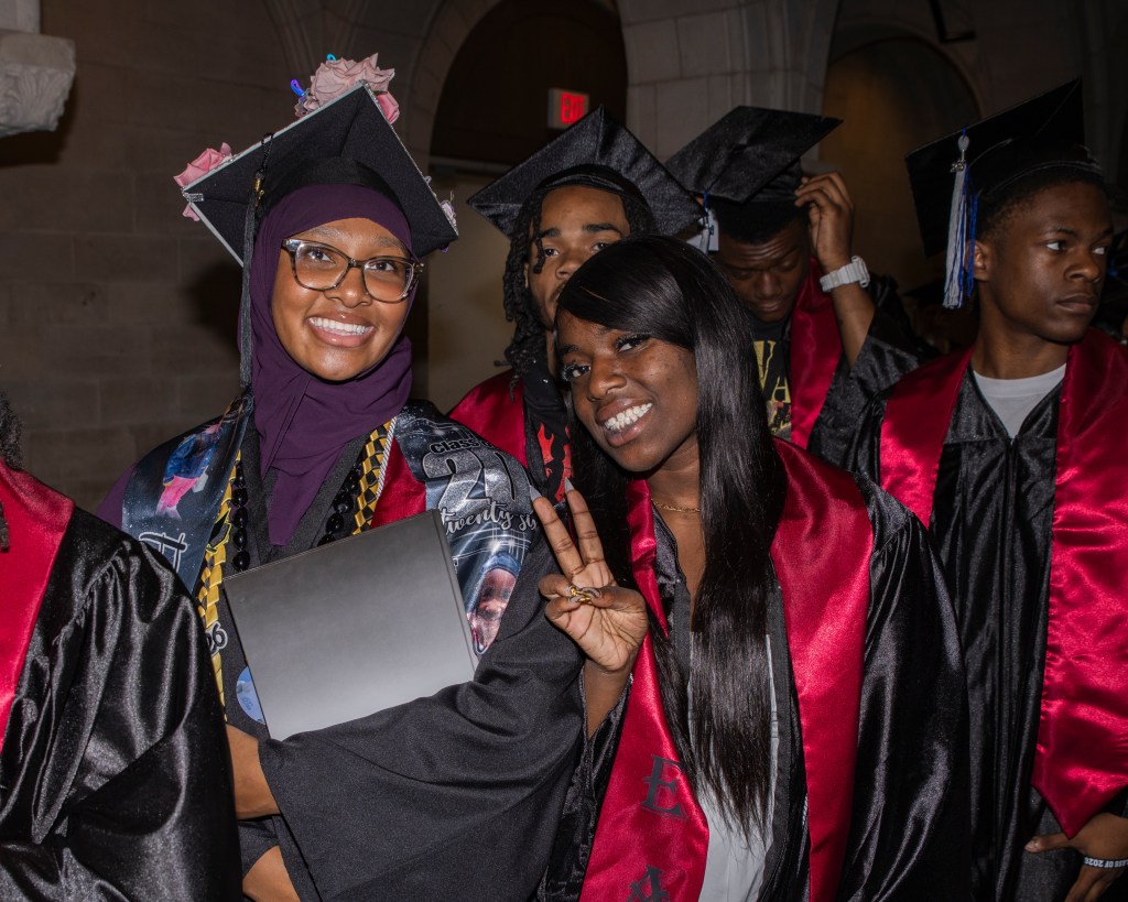 Philadelphia graduates celebrate together while wearing caps, gowns and personalized stoles.