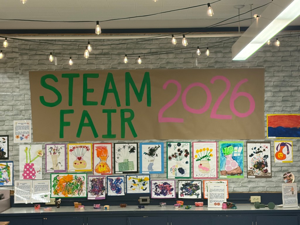 Las obras de arte y los proyectos de los alumnos se exponen bajo un cartel de la Feria STEAM 2026.