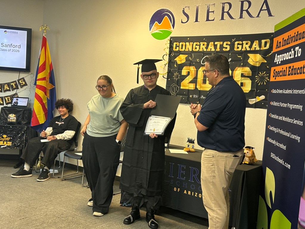 A Sierra School of Gilbert graduate receives recognition during the Class of 2026 ceremony while family and staff look on.