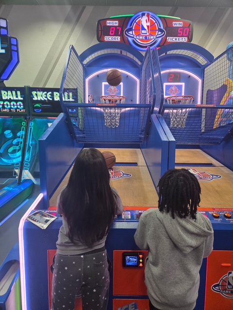 Students participate in an arcade basketball game that encourages teamwork and friendly competition.
