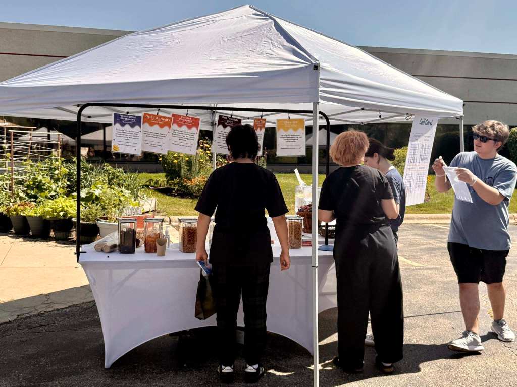 Students participating in a nutrition station featuring healthy snacks and trail mix ingredients.