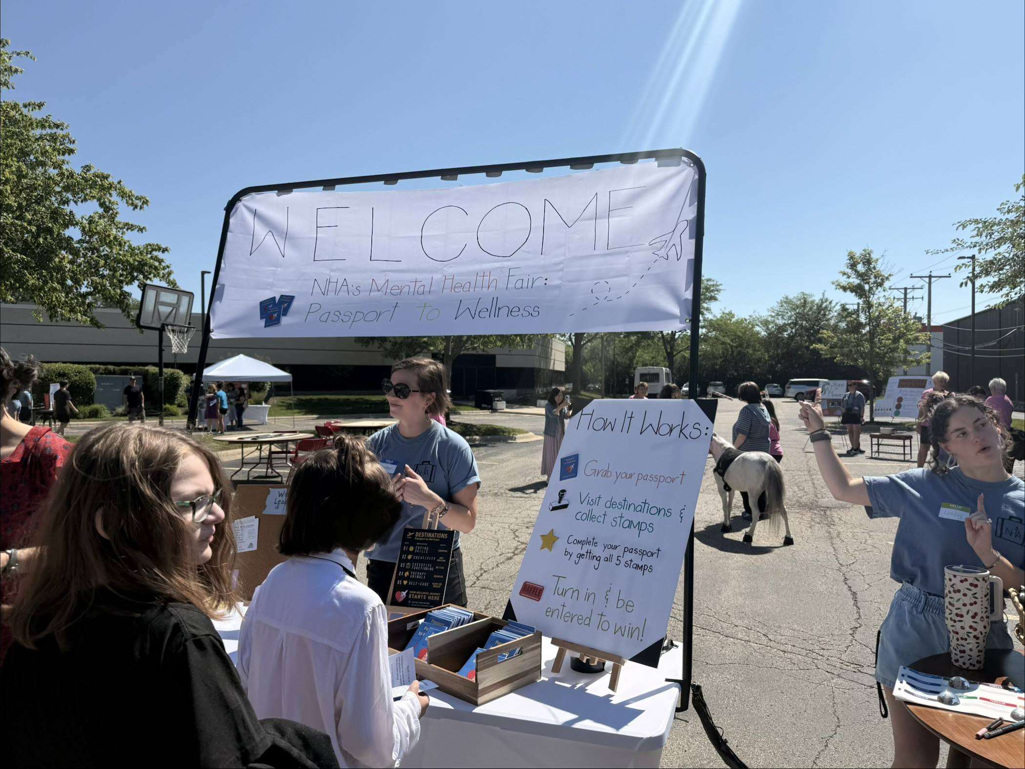 NewHope Academy Mental Health Fair welcome station with passport instructions and activity booths.