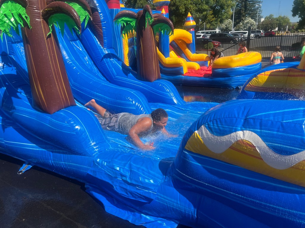 Student enjoys a water slide during summer activities at Sierra School of Sacramento.