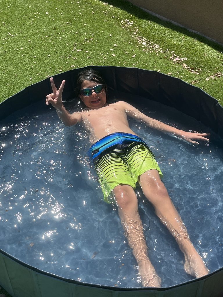 Student relaxes in an outdoor pool during a summer ESY water activity.
