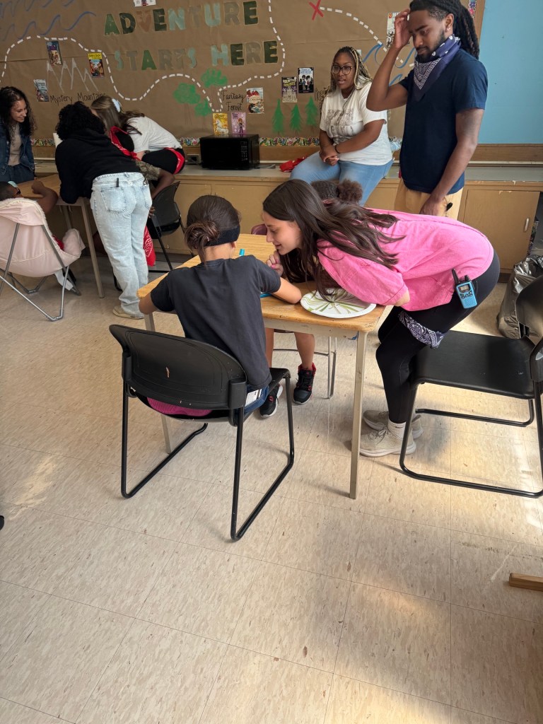 Un alumno y un miembro del personal colaboran durante una actividad en equipo en la escuela primaria High Road School de Hartford.