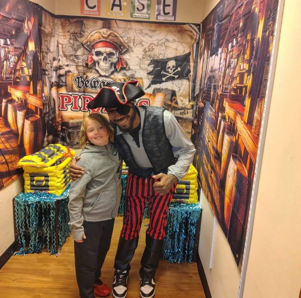 Un alumno posa junto a un miembro del personal disfrazado de pirata durante la actividad temática «Island Adventures ESY» de The Graham Academy.