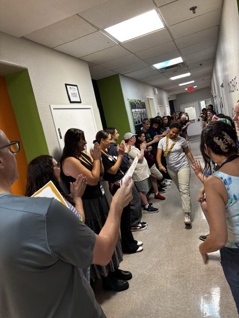 Students walk through a hallway as Sierra Gilbert staff and classmates applaud during a respect recognition celebration.