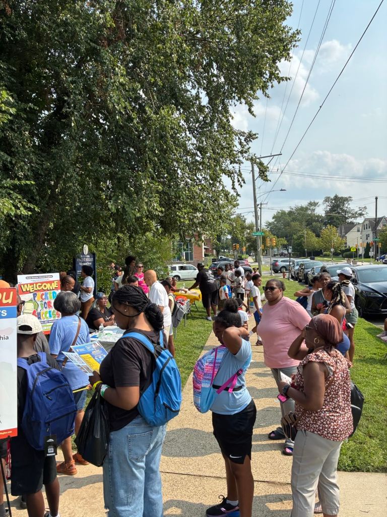 Families and children gather along the sidewalk during the Packed for Success back-to-school event in West Philadelphia.