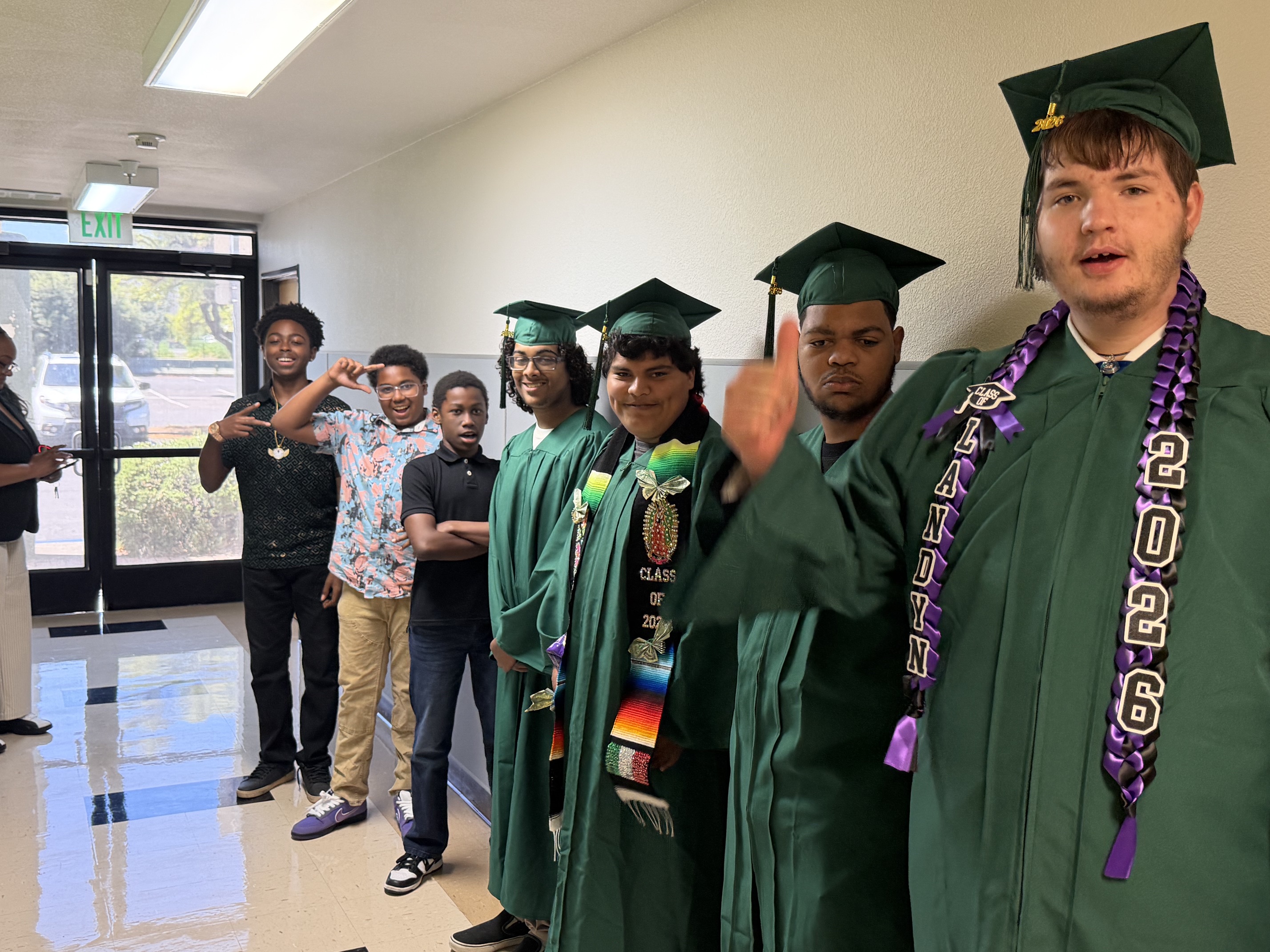Los alumnos de la Sierra School del condado de Solano se reúnen con los graduados de 2026, que llevan togas y birretes verdes.