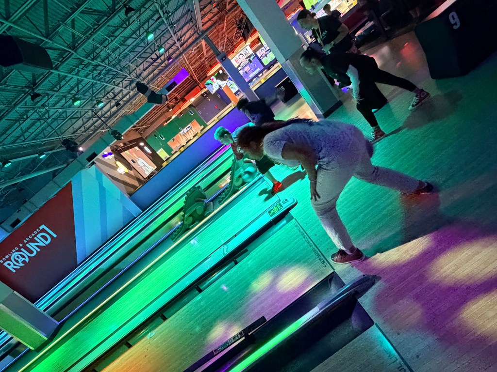 Sierra Gilbert student practices bowling during a community outing with classmates and staff.