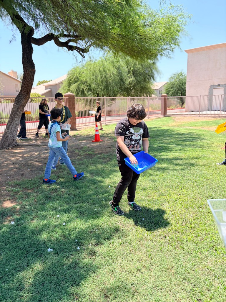 Sierra School of Gilbert student carries a tray of snowballs during an outdoor Fun Friday activity.