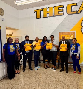 El personal de la Escuela de Estudiantes Destacados de la ciudad de Valdosta y los responsables del distrito posan juntos durante una ceremonia especial de reconocimiento.