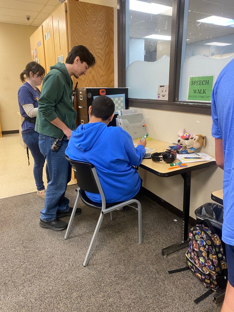 Un miembro del personal de Lattice Educational Services ayuda a un alumno durante una actividad en el aula.