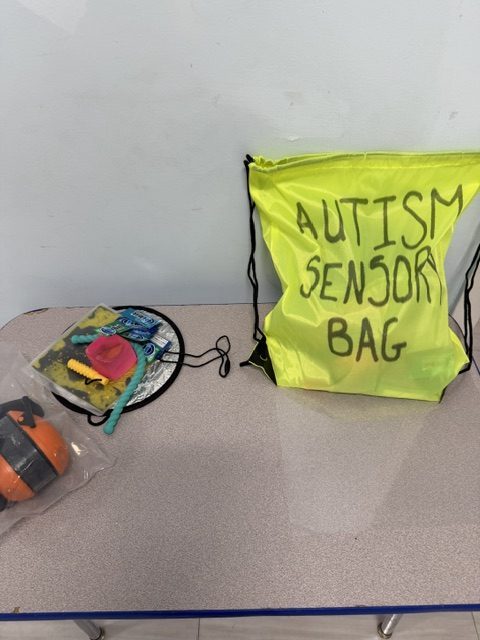 Yellow autism sensory bag displayed with fidgets and sensory tools prepared by B.E.S.T. Academy staff.