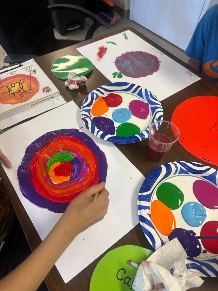 Colorful student-created dot artwork and paint supplies displayed during the International Dot Day activity.