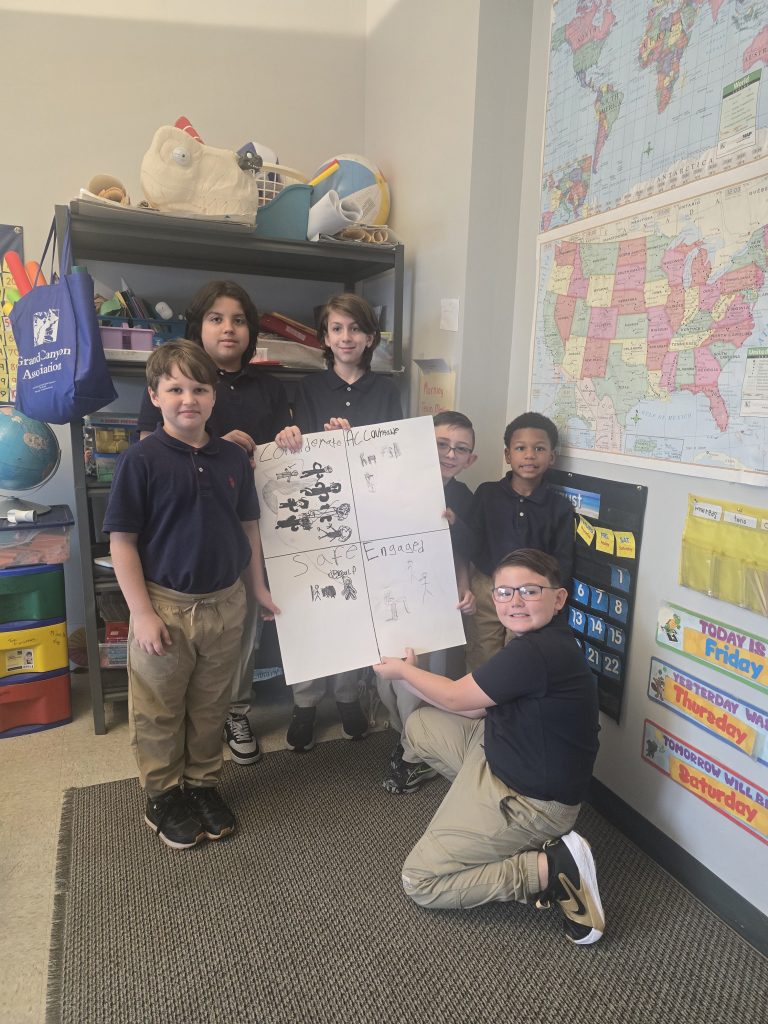 Students posing with a classroom expectations poster during the first week of school