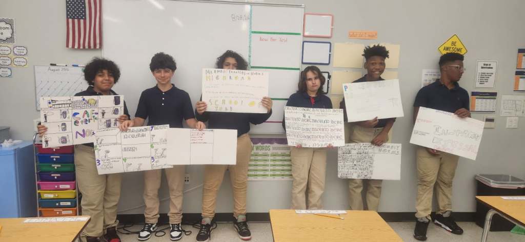 High Road students displaying posters illustrating classroom norms and expectations
