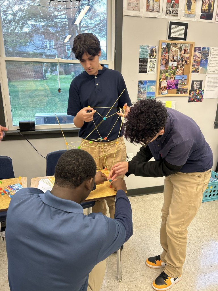 Students collaborating to build a structure during a High Road team-building exercise
