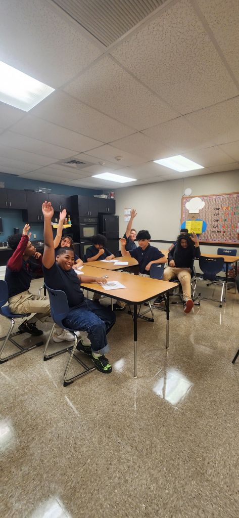 High Road students raising their hands during a classroom discussion