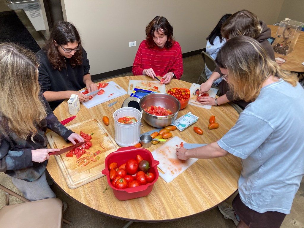 Alumnos de la NewHope Academy participando en una actividad de jardinería y preparación de comida