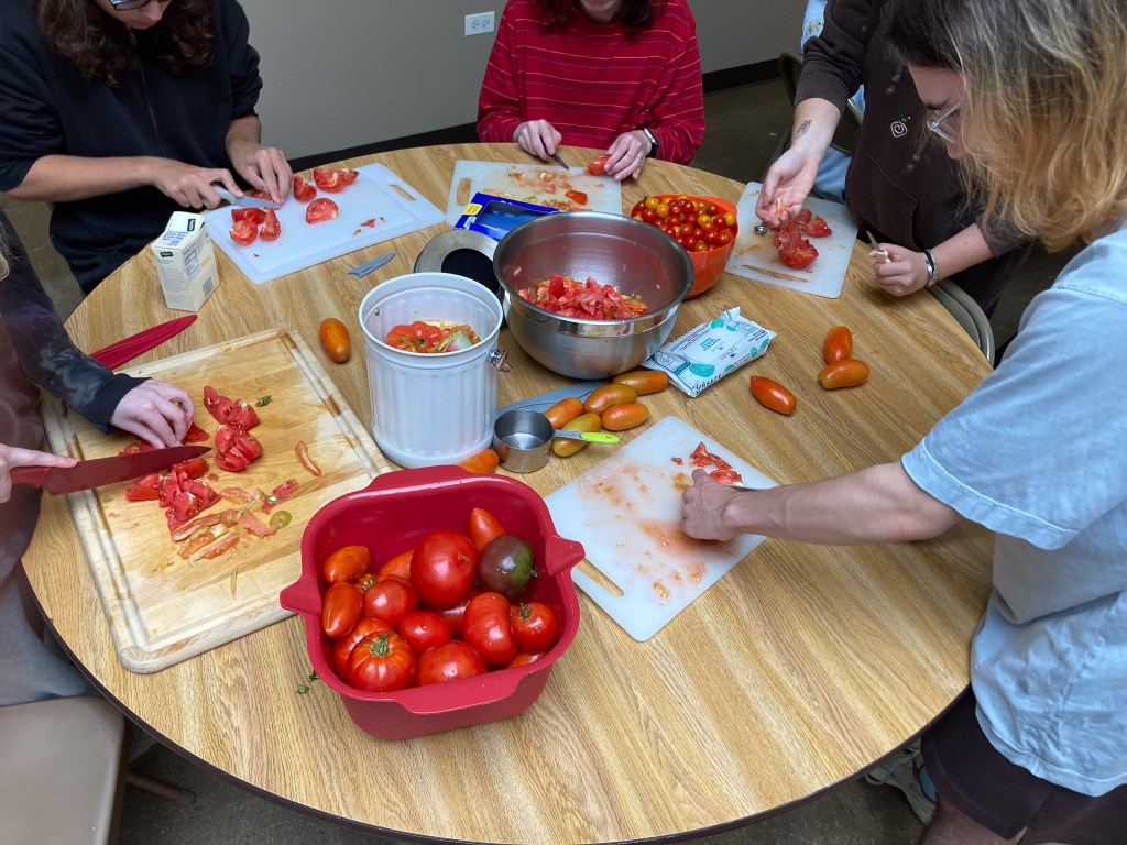 Un alumno prepara tomates frescos recogidos del huerto de la Academia NewHope