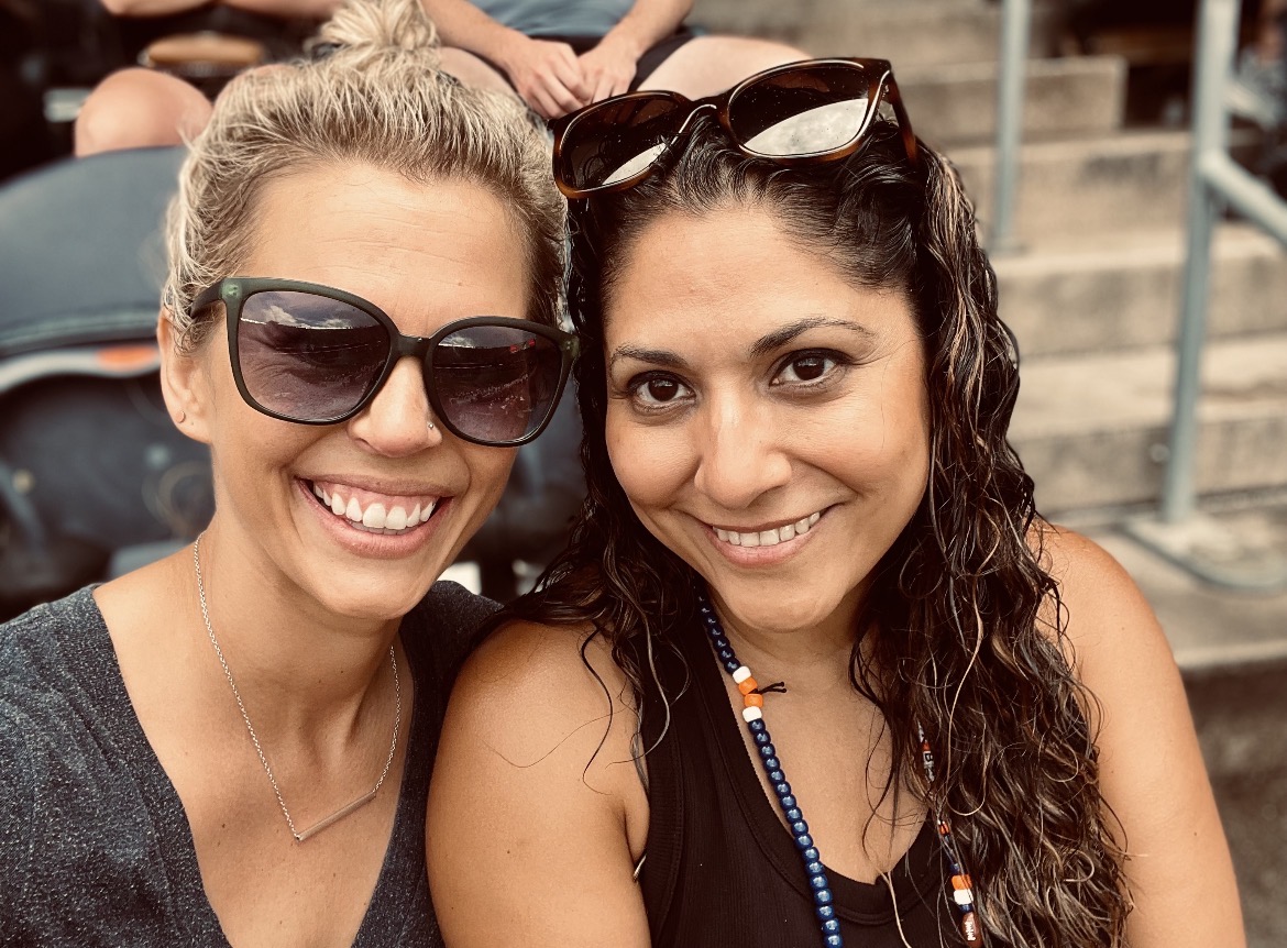 Bethany Arteaga and Meaghan Torrence smiling together at an outdoor event