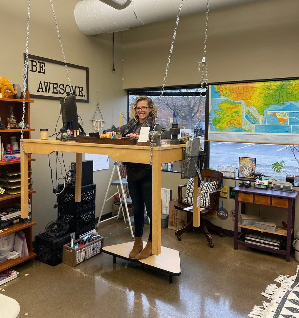 NewHope Academy educator standing at a suspended classroom desk