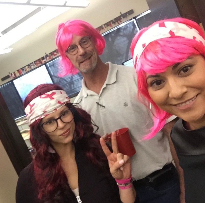 NewHope Academy staff members wearing colorful wigs during a school activity