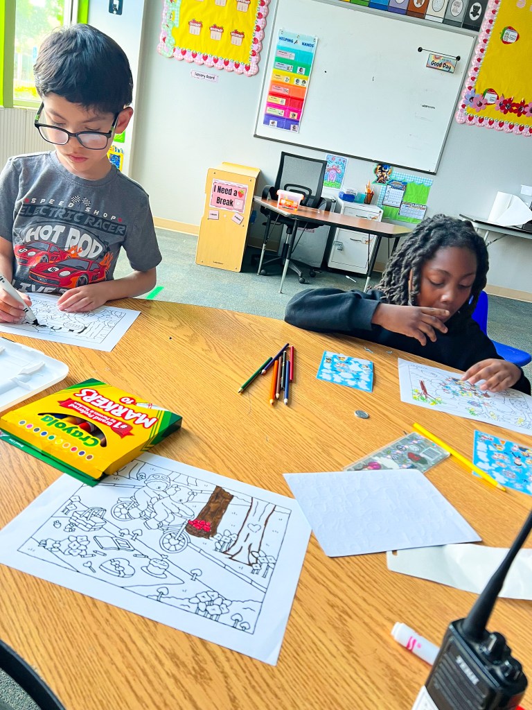 Students color activity pages together in a classroom at Sierra School of Sacramento.