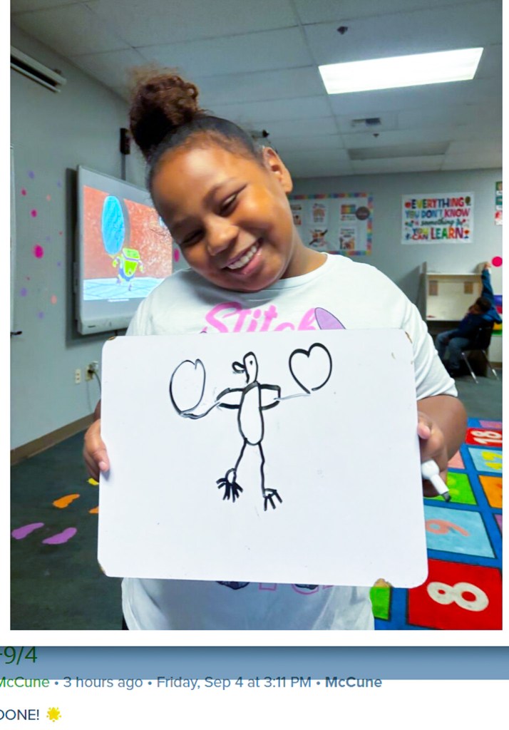 Sierra School of Sacramento student smiles while holding up a drawing during a classroom activity.