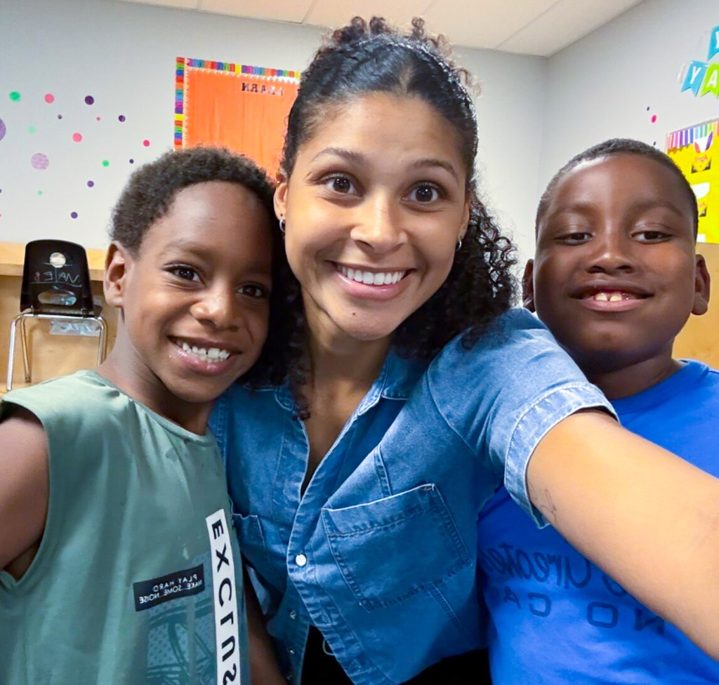 Sierra School of Sacramento staff member smiles with two students during the start of the school year.
