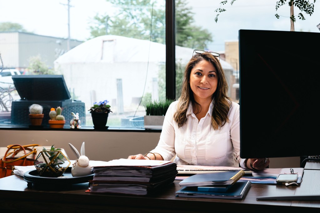 NewHope Academy Director Bethany Ortega smiling while seated at her office desk.